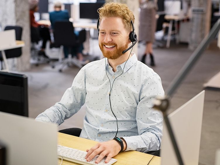 Mann mit Headset am Computer